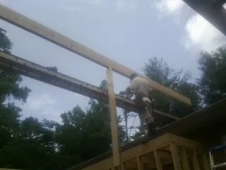 Carpenter setting a ridge beam over a new addition frame — Ice Dam Removal by Roofing Brothers in Flagtown