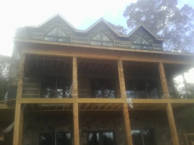 Dormers and porch framing on a large log home under construction — Roof Coating work by our crew in Flagtown
