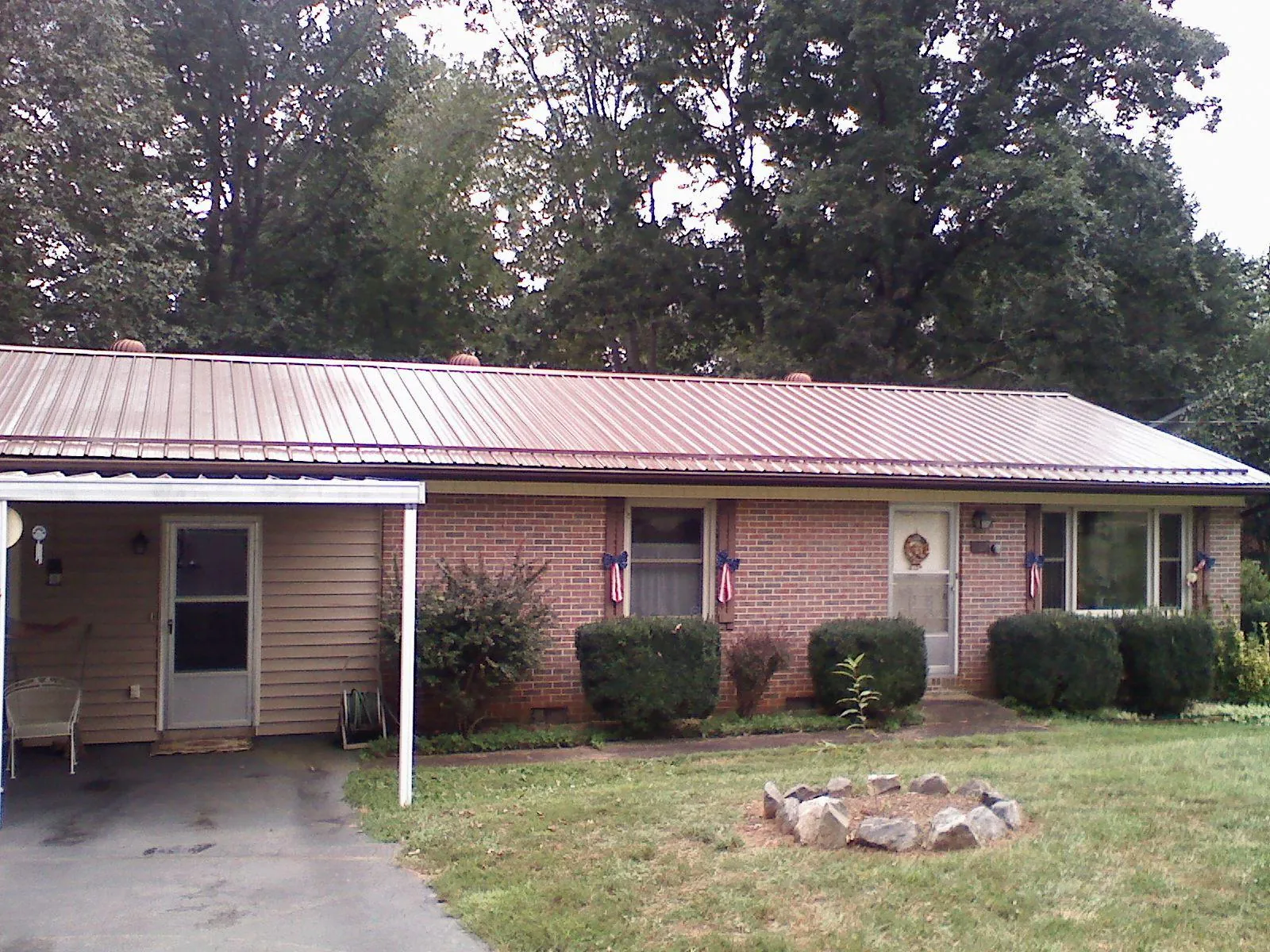 Bronze metal roof and carport on a brick ranch home — Roof Repair work by our crew in Flagtown